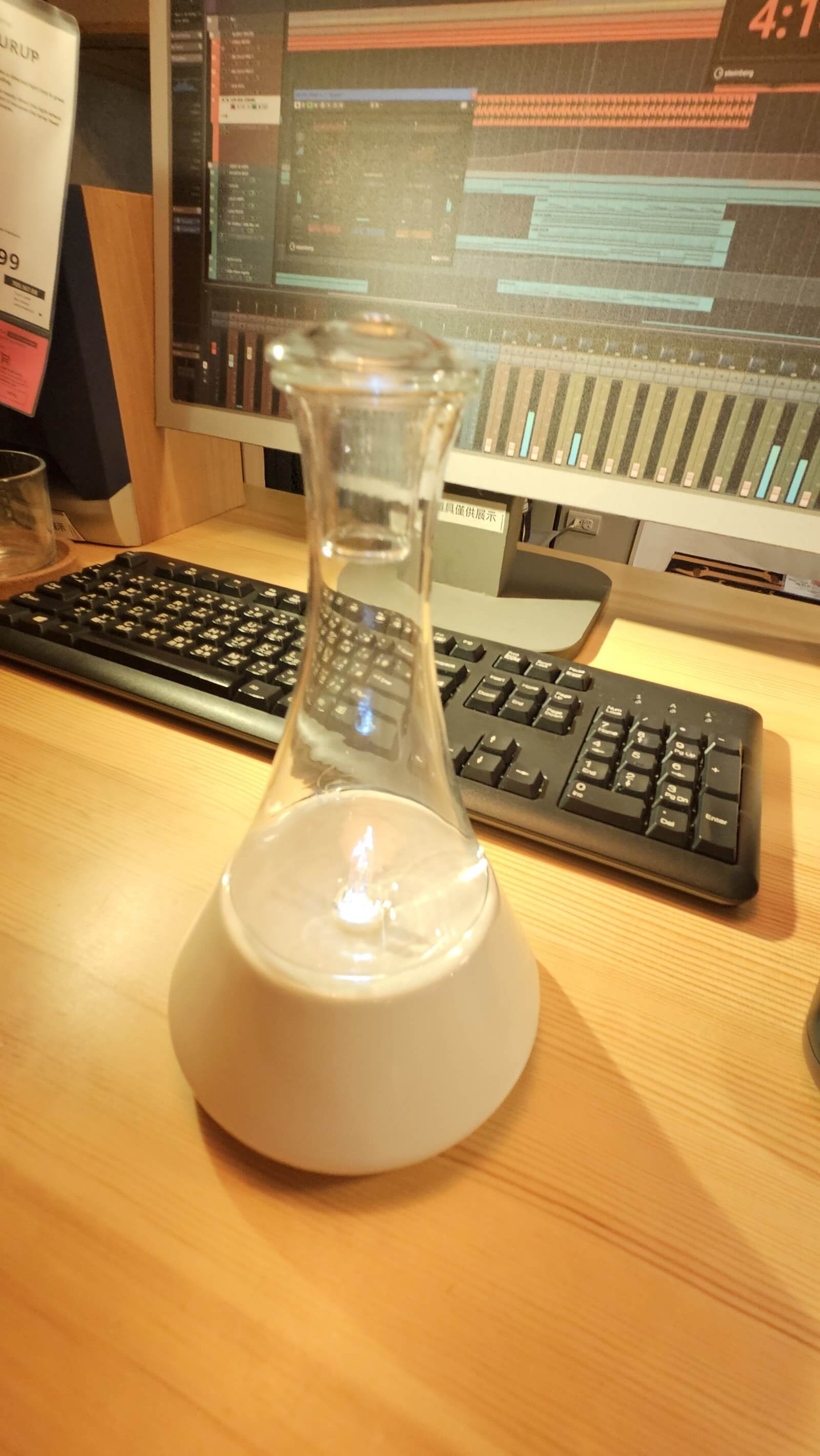 白色錐形玻璃瓶的無水精油擴香機，放在書桌螢幕前