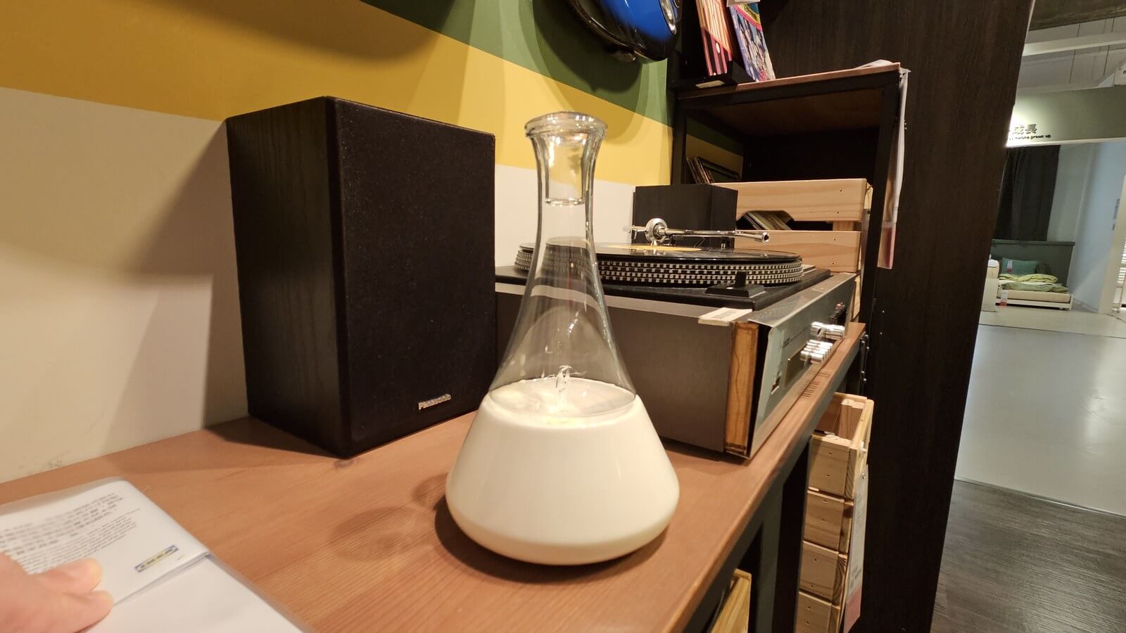 乳白錐形瓶身造型擴香儀,層架與黑膠唱機場景