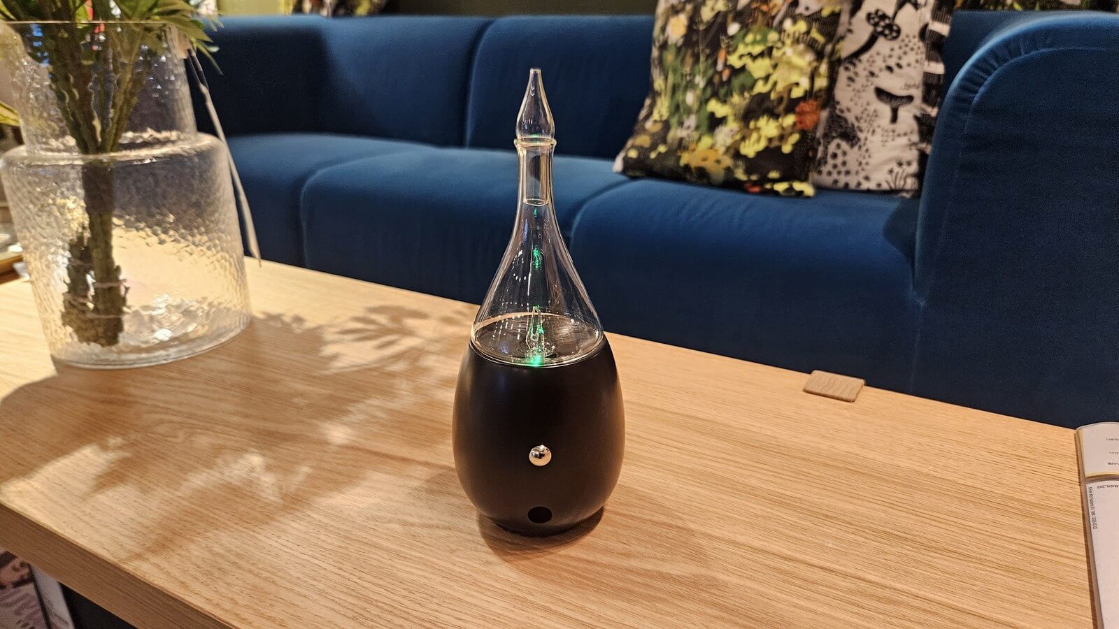 放在客廳邊几上的擴香儀，木質與玻璃造型適合居家空間的氣味氛圍